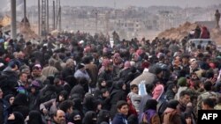 Syrian families, fleeing from various eastern districts of Aleppo, queue to get onto governmental buses, Nov. 29, 2016, in the government-held eastern neighborhood of Jabal Badro, before heading to government-controlled western Aleppo. The crisis in Syria is currently the United Nations' biggest humanitarian concern.