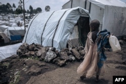 FILE - A girl walks around the Rusayo IDP camp, home to tens of thousands of war-displaced people, situated at the foot of the active Nyiragongo volcano, on the outskirts of Goma, eastern Democratic Republic of Congo, on October 2, 2023.