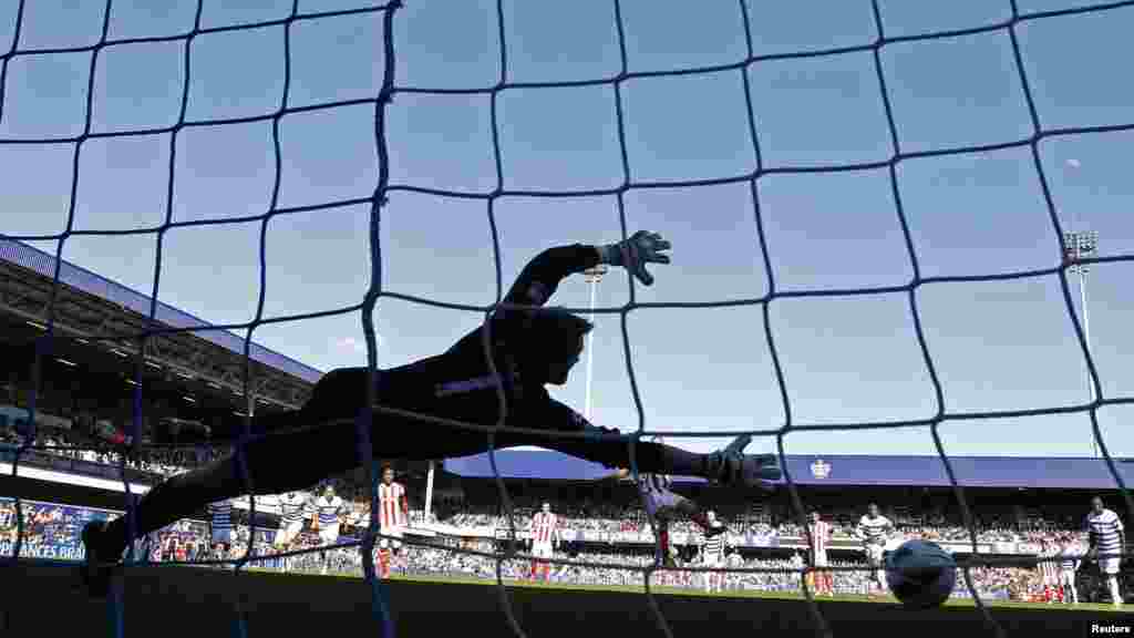 Stoke City's Jon Walters (C) scores a penalty past Queens Park Rangers' goalkeeper Robert Green during their English Premier League soccer match at Loftus Road in London April 20, 2013.