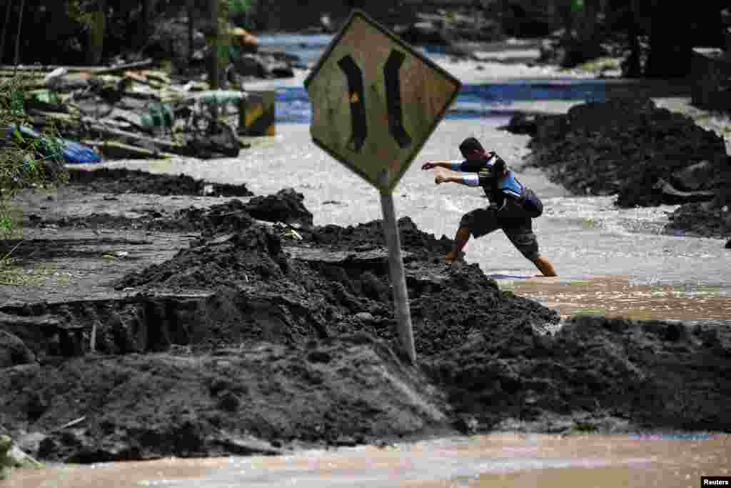 A local walks through water flowing in an area affected by the eruption of Mount Semeru volcano, in Kamar Kajang, Candipuro district, Lumajang, East Java province, Indonesia.