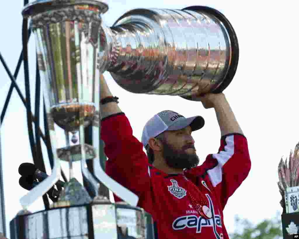 Washington Capitals NHL hockey team left wing Alex Ovechkin from Russia holds up the Stanley Cup during a victory parade and rally at The National Mall in Washington.