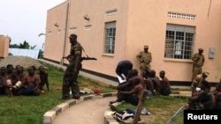 Binh sĩ Lực lượng Quốc phòng Nhân dân Uganda, UPDF, bắt những người bị tình nghi là thành viên nhóm dân quân sau khi các tay súng tấn công thị trấn Bundibugyo ở Tây Uganda, 6/7/14