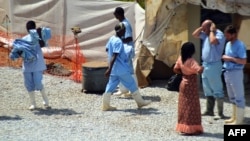 Health workers walk in an isolation center for people infected with Ebola at Donka Hospital in Conakry, April 14, 2014. 