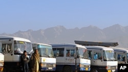 Men wait at the Peshawar bus station in Kabul where buses leave for the eastern provinces in Afghanistan and the Pakistani border