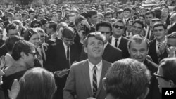 FILE - In this June 7, 1966, file photo Sen. Robert F. Kennedy is surrounded by students and newsmen as he tours Stellenbosch, South Africa, during a five-day visit to South Africa as the guest of the multiracial National Union of South African students.