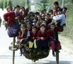 Anak-anak India naik kereta (semacam becak) dalam perjalanan pulang dari sekolah di pinggiran New Delhi, 26 Februari 2001. (REUTERS/Pawel Kopcznski/Files)