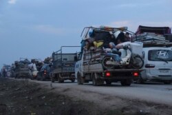 Truckloads of civilians flee a Syrian military offensive in Idlib province on the main road near Hazano, Syria, Dec. 24, 2019.