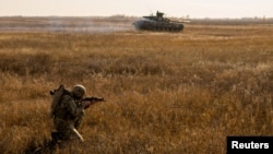 FILE - A serviceman of the Ukrainian Armed Forces takes part in military drills at a training ground near the border with Russian-annexed Crimea in Kherson region, Ukraine, in this handout picture released by Ukraine's military.