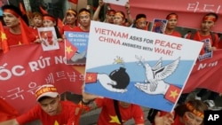FILE - Vietnamese protesters hold up anti-China protest placards during a rally at the Chinese Embassy in Seoul, South Korea, July 24, 2016.