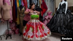 Leonora Buenviaje shows a dress made of used sacks of rice and plastic bags, at her shop in Cainta in the Philippines on March 3, 2022. (REUTERS/Lisa Marie David)