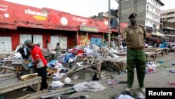A policeman secures the scene of twin explosions at the Gikomba open-air market for second-hand clothes in Kenya's capital Nairobi, May 16, 2014.