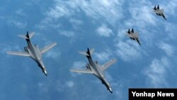 20일 한반도 상공에서 미 공군 B-1B 전략폭격기(왼쪽)가 한국 공군 F-15K 전투기의 엄호를 받으며 비행하고 있다.