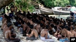 Para pengungsi Rohingnya duduk di tanah saat ditangkap oleh Angkatan Laut Thailand di laut Andaman, 12 Desember 2008 (Foto: dok). 