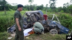 Security personnel cover the body of a Buddhist monk as they investigate the site of a bombing in the troubled southern province of Yala, May 16, 2011