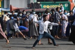 Pro-military supporters throw projectiles at residents in Yangon on Feb. 25, 2021, following weeks of mass demonstrations against the military coup.