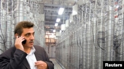 FILE - An official from Iran's Atomic Energy Organization stands in front of uranium enriching centrifuges at a 2009 an exhibition of Iran's nuclear achievements at Shahid Beheshti University in Tehran.