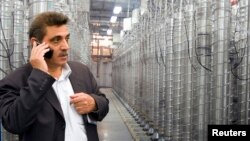 FILE - An official from Iran's Atomic Energy Organization stands in front of uranium enriching centrifuges at a 2009 exhibition of Iran's nuclear achievements at Shahid Beheshti University in Tehran.