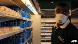 FILE - An employee of Chandarana Foodplus supermarket in Adlife Plaza takes items off the shelf to fill out an online shopping order in Nairobi, Kenya, May 05, 2020.