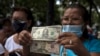 Foto de archivo. Una mujer sostiene billetes de dólares durante una protesta de trabajadores públicos y jubilados en Caracas, Venezuela, el 6 de septiembre de 2022. (Foto AP/Ariana Cubillos)