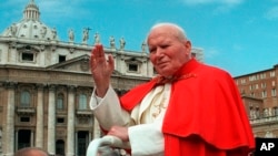 FILE - In this file photo taken on April 23, 1997, Pope John Paul II waves to faithful as he crosses St. Peter's Square at the Vatican.