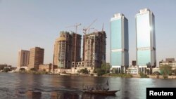 A boat passes buildings under construction and the two towers of the Bank of Egypt building (R), overlooking the river Nile in Cairo, June 7, 2013. 