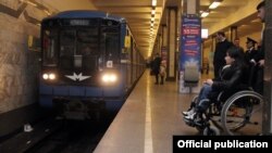 Əlil arabasında metroda hərəkət edən insan 