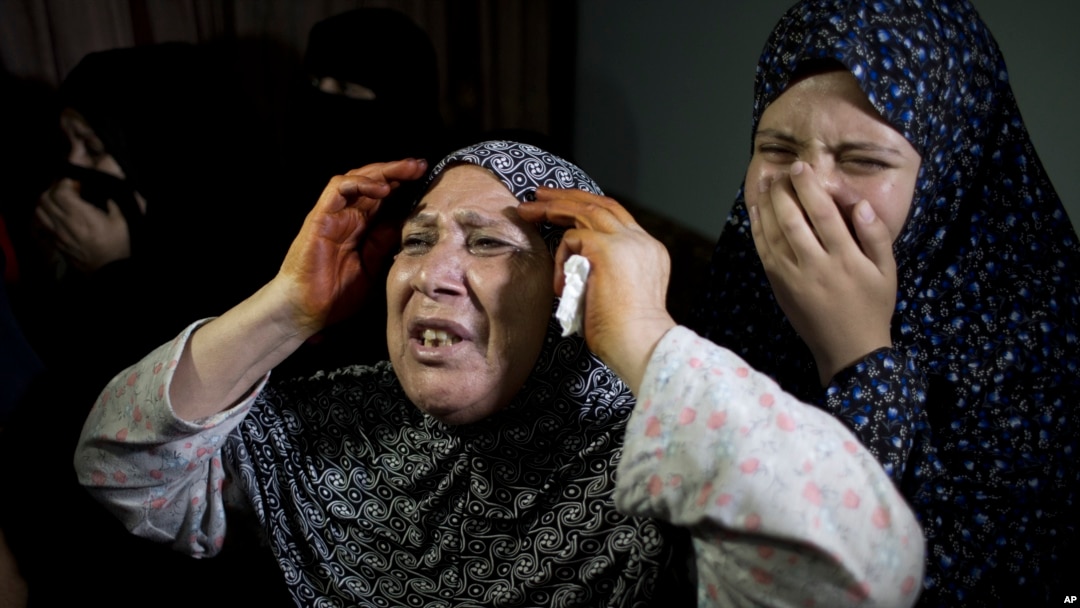 Warga Palestina berduka saat pemakaman seorang anak berusia dua tahun, Rahaf Hassan, dan ibunya yang berusia 30 tahun dan sedang hamil, Noor Hassan, yang tewas akibat serangan udara Israel pada hari Sabtu pagi (10/10), di Gaza. (AP Photo/ Khalil Hamra)