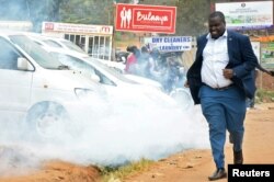 A man runs from teargas used to disperse supporters of Ugandan musician turned politician, Robert Kyagulanyi also known as Bobi Wine.