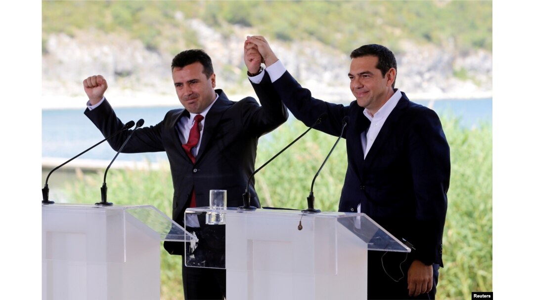 FILE - Greek Prime Minister Alexis Tsipras and Macedonian Prime Minister Zoran Zaev gesture before the signing of an accord to settle a long dispute over the former Yugoslav republic's name in the village of Psarades, in Prespes, Greece, June 17, 2018.