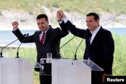 FILE - Greek Prime Minister Alexis Tsipras and Macedonian Prime Minister Zoran Zaev gesture before the signing of an accord to settle a long dispute over the former Yugoslav republic's name in the village of Psarades, in Prespes, Greece, June 17, 2018.