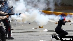 Una manifestante es atacada por la espalda por policías nacionales durante los enfrentamientos en El Cafetal, al este de Caracas.
