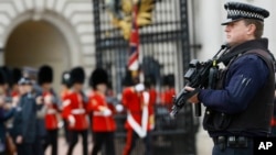 Un policía armado vigila una de las entradas al palacio de Buckingham luego del ataque terrorista de ayer por la tarde.