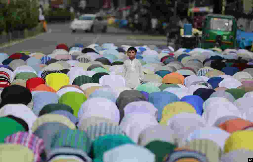 A Bangladeshi child stands in between elders offering Friday prayers, ahead of a protest rally against the persecution of Rohingya Muslims in Myanmar, in Dhaka, Bangladesh.