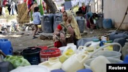 A woman waits to fill water in her containers from a municipal tap in New Delhi, India, Feb. 21, 2016. India deployed thousands of troops in a northern state to quell protests that have severely hit water supplies to Delhi.