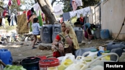 A woman waits to fill her containers with water from a municipal tap in New Delhi, India, Feb. 21, 2016. Protests by the Jat community have disrupted water supplies to about 10 million people.