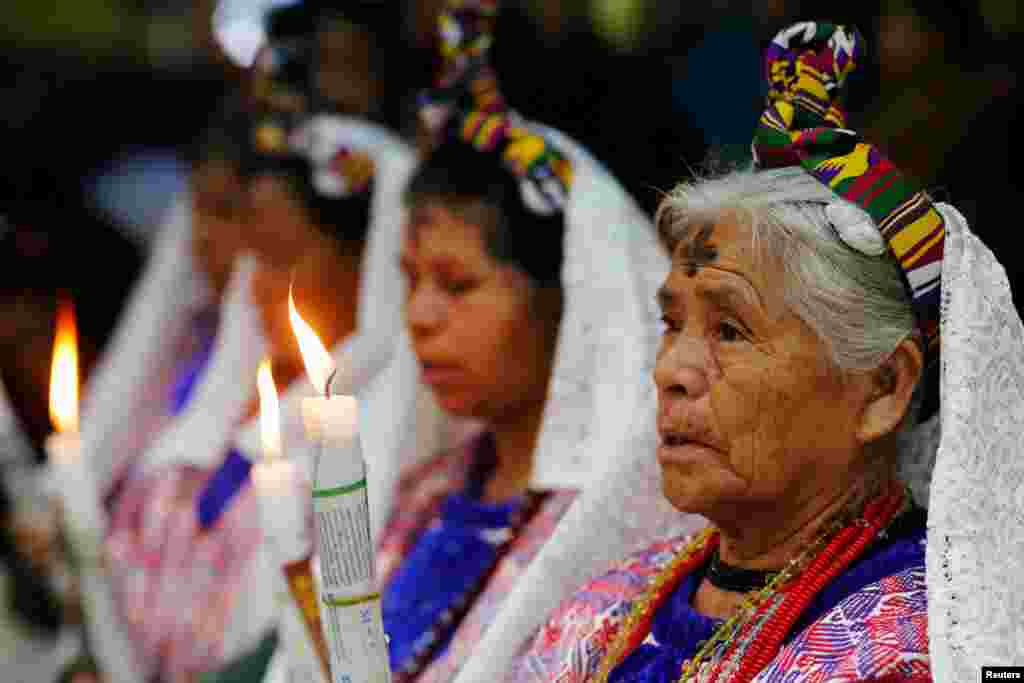 Indigenous Mayan women, with a cross of ashes on their foreheads, attend an Ash Wednesday mass in the municipality of San Juan Sacatepequez, Guatemala, Feb. 14, 2018.