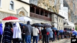 Vjernici čekaju u redu ispred manastira Ostrog ( Foto: AP/Risto Božović)