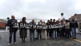 ARCHIVO - Activistas sostienen una pancarta que dice "Por vuestra libertad y la nuestra" durante un piquete en memoria de una manifestación de siete personas en 1968 en la Plaza Roja de Moscú, el domingo 25 de agosto de 2013.