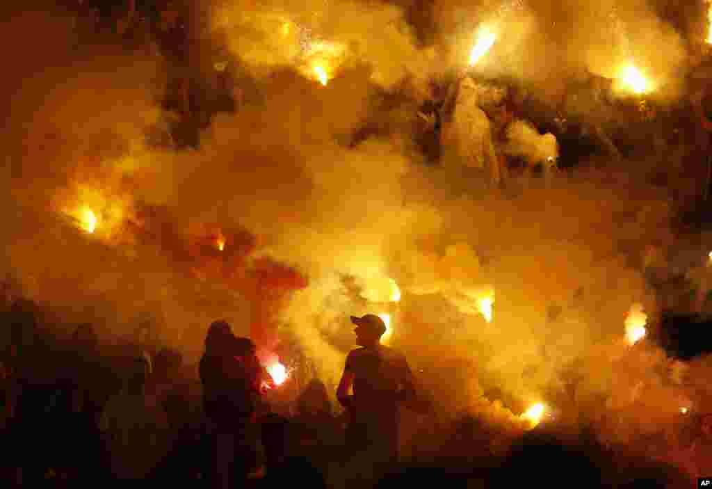 Partizan soccer fans light torches during a Serbian National soccer league derby match between Red Star and Partizan, in Belgrade, Serbia, April 25, 2015. 