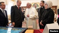 Pope Francis talks with Turkish President Tayyip Erdogan and his wife Emine (R) during a private audience at the Vatican, Feb. 5, 2018. 