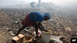 Nadia Prophete, 12, collects food from a trash to sell to pig owners at the Cite Soleil area of Port-au-Prince, Haiti, June 12, 2017. 