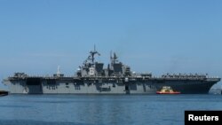 U.S. Marines and sailors man the rails aboard the USS America as they leave port and deploy to the Pacific from Naval Base San Diego in San Diego, California, July 7, 2017.