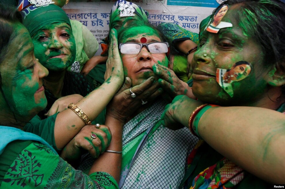 Supporters of Trinamool Congress (TMC) celebrate after learning the initial poll results of the West Bengal Assembly elections, in Kolkata, India.