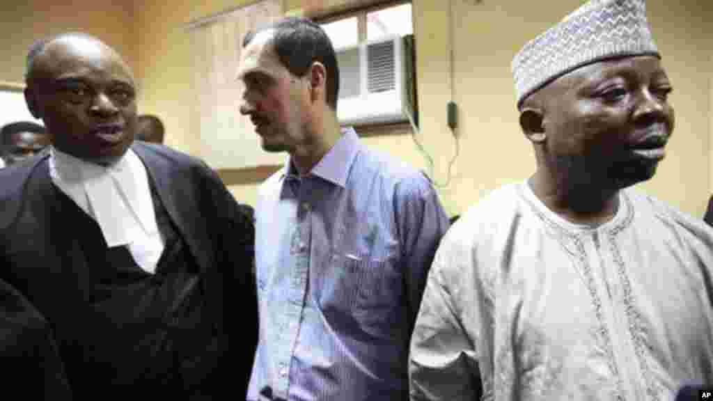 Chris Uche, left, lawyer of Iranian, Azim Aghajani, centre, and Nigerian, Usman, Abbas, right, speaks, as the waits for a court verdict at the Federal High Court, in Lagos, Monday, May 13, 2013.