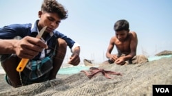 Young fishermen at work on Kutubdia. (J.Owens/VOA)