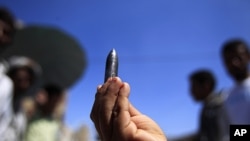 A bullet fired by security forces during clashes with tribal fighters loyal to the opposition is displayed during a rally to demand the ouster of Yemen's President Ali Abdullah Saleh in the southern city of Taiz, October 28, 2011.