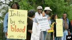 FILE - Waynetta Lawrie, left, of Tulsa, Oklahoma, stands with others at the state Capitol in Oklahoma City during a demonstration by several Cherokee Freedmen and their supporters, March 27, 2007. 