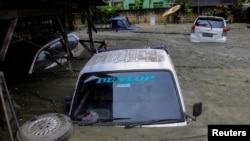 Mobil-mobil tampak terendam akibat bencana banjir dan tanah longsor di Sentani, Papua hari Minggu (17/3). (Foto. Gusti Tanati/Antara via Reuters)