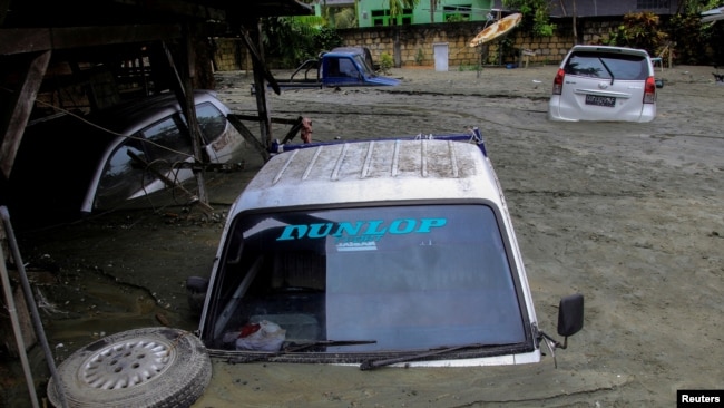 Mobil-mobil tenggelam akibat bencana banjir dan tanah longsor di Sentani, Papua hari Minggu (17/3). (Foto. Antara/Gusti Tanati)