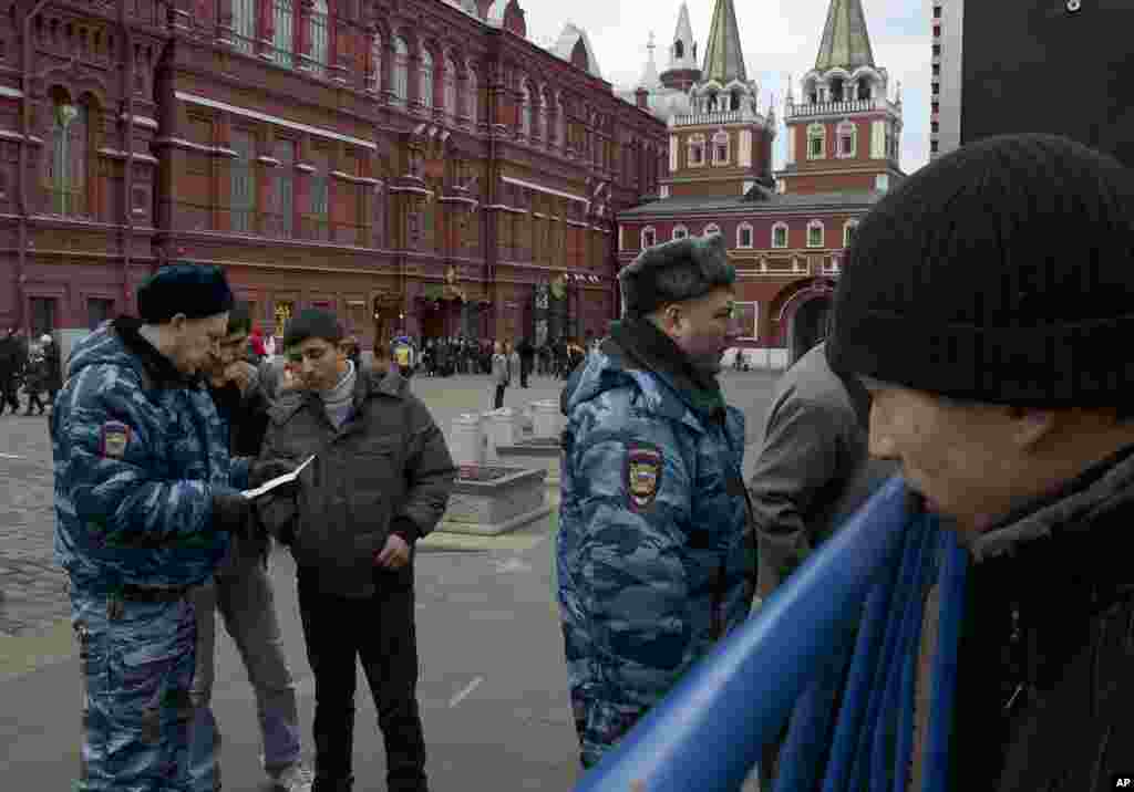 Russian police officers check the identity papers of migrant workers arriving at Red Square ahead of the New Year&#39;s Eve festivities, Moscow, Russia, Dec. 31, 2013.&nbsp;